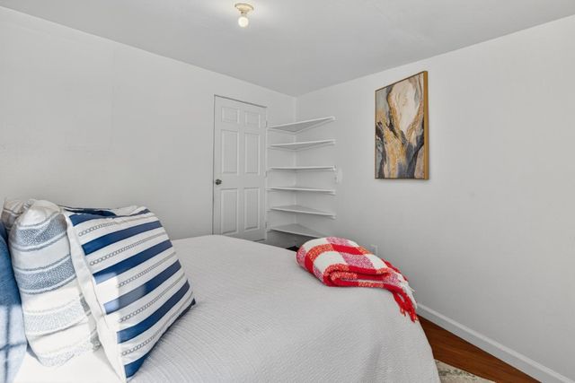 a bedroom with a bed and a painting on the wall