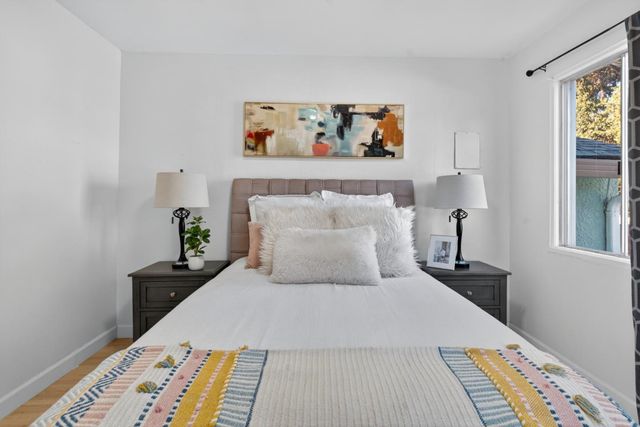 a bedroom with a bed and a painting on the wall