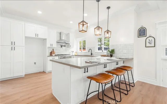 a kitchen with stainless steel appliances granite countertop white cabinets and wooden floor