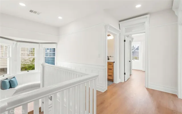 a view of a hallway with wooden floor and windows