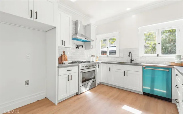 a kitchen with a sink cabinets appliances and a window