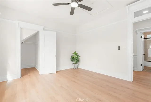 a view of a big room with wooden floor and ceiling fan