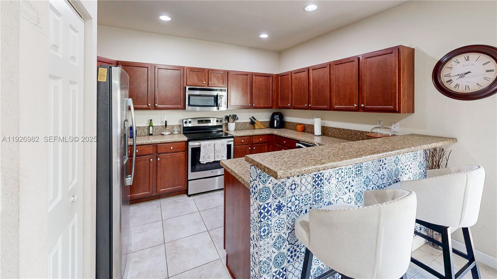 3218 Southeast 5th Court Homestead, FL 33033 - Photo 16 of 68 a kitchen with stainless steel appliances granite countertop a table chairs sink and cabinets