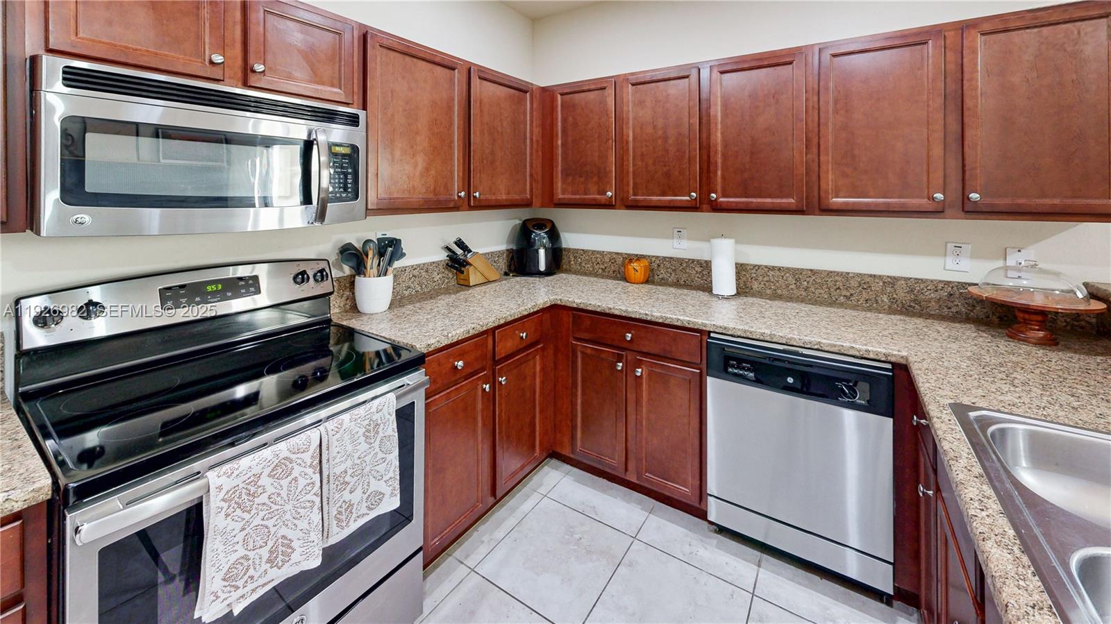 3218 Southeast 5th Court Homestead, FL 33033 - Photo 17 of 68 a kitchen with granite countertop a stove microwave and sink