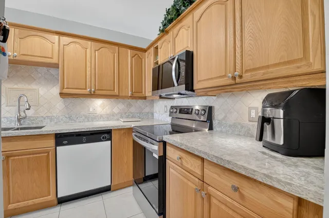 a kitchen with stainless steel appliances granite countertop a sink a stove and a microwave