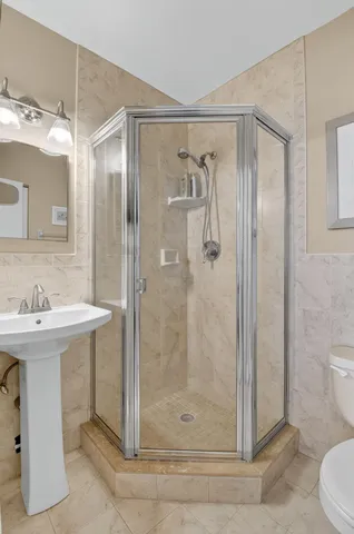a bathroom with a sink a toilet and shower