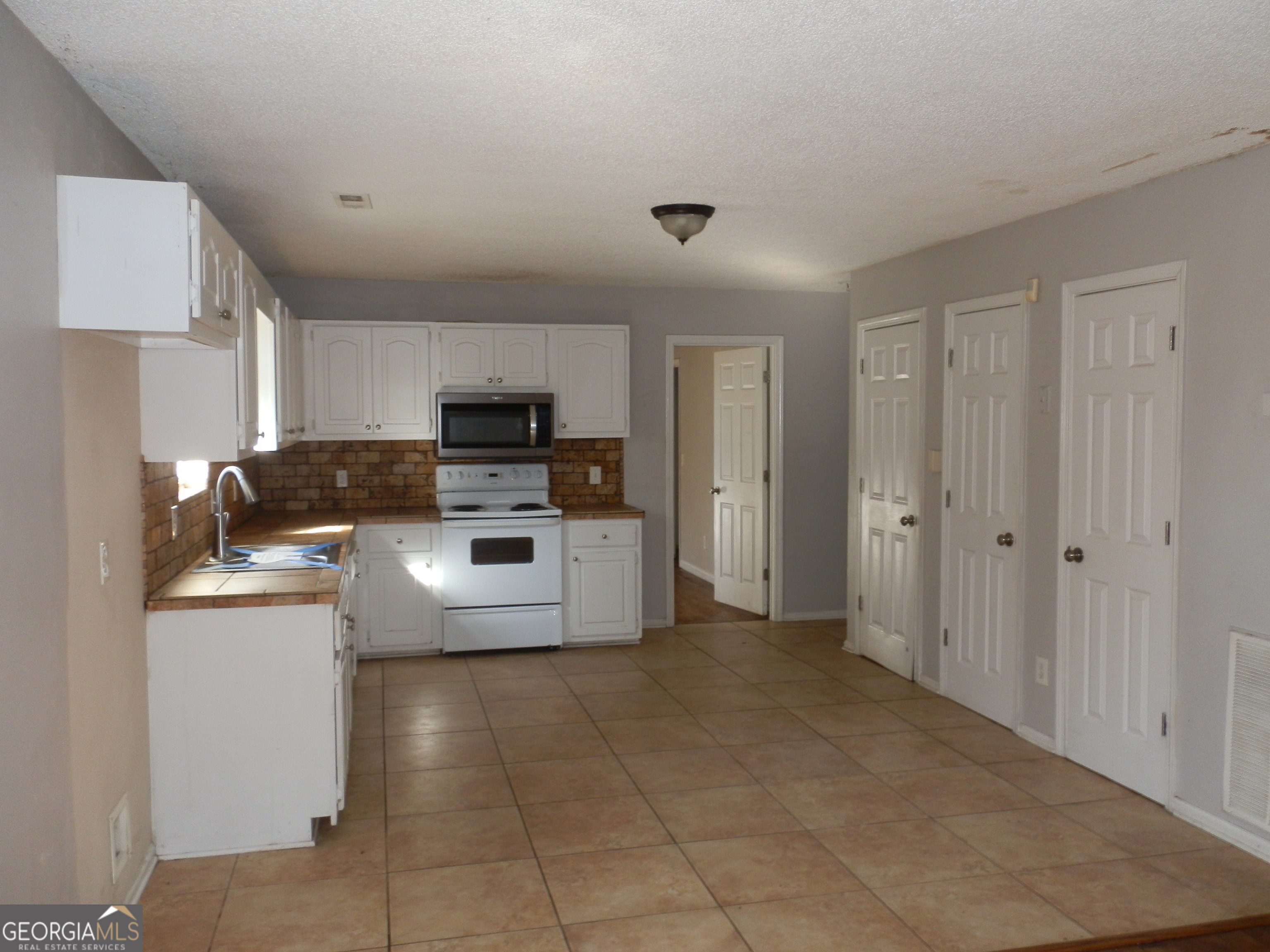 114 Lindsey Court Northeast Calhoun, GA 30701 - Photo 13 of 26 a kitchen with stainless steel appliances a stove a microwave a sink a refrigerator and cabinets