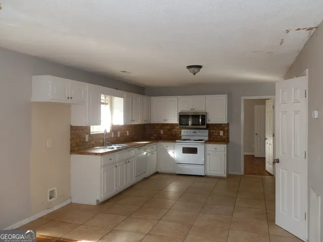 a kitchen with a sink and white cabinets