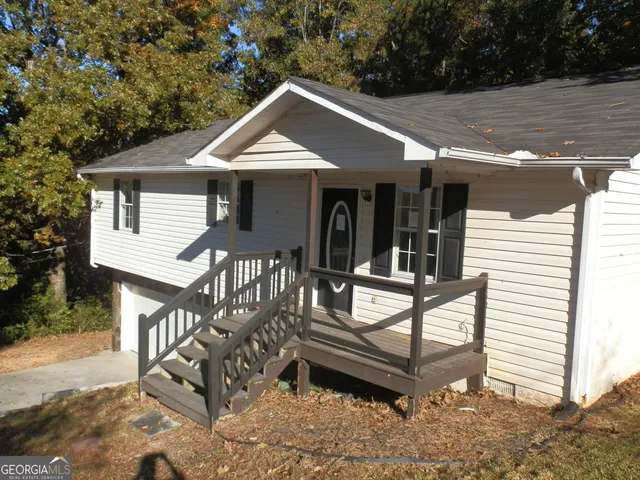 a view of a house with backyard and sitting area