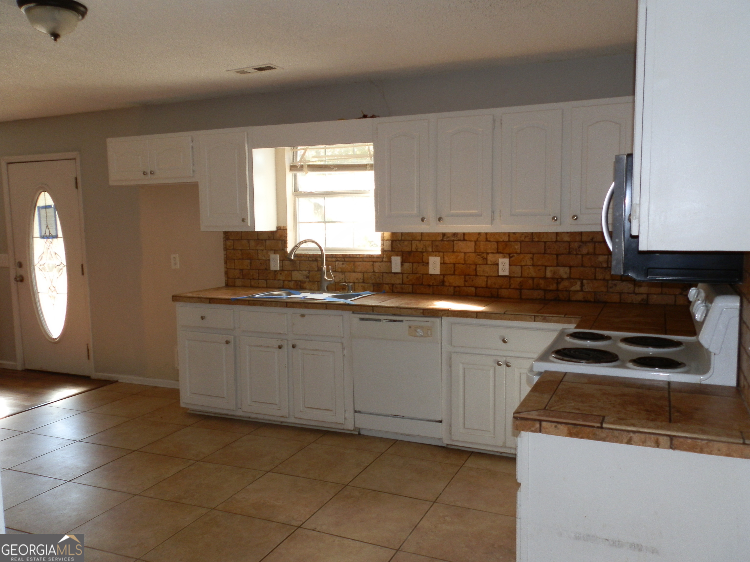 114 Lindsey Court Northeast Calhoun, GA 30701 - Photo 22 of 26 a kitchen with granite countertop a sink a stove and cabinets
