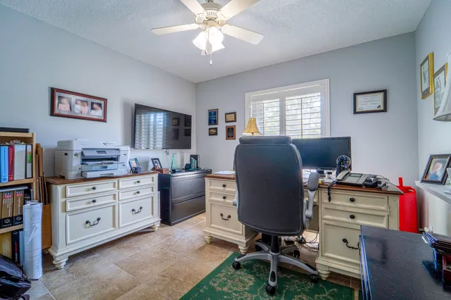 a view of a workspace with furniture and a window