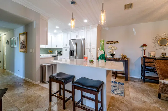 a kitchen with a dining table chairs refrigerator and sink