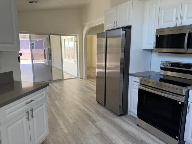 a kitchen with kitchen island a counter top space a sink and stainless steel appliances