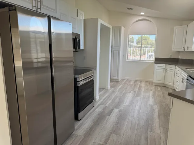 a kitchen with granite countertop white cabinets and white appliances