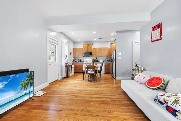 a living room with furniture and dining table with kitchen view