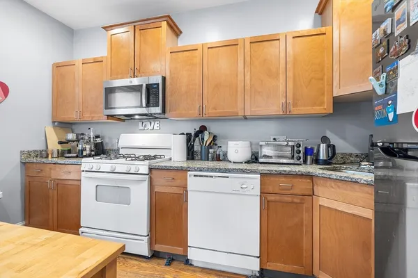 a kitchen with stainless steel appliances granite countertop a stove a sink dishwasher and a microwave oven with cabinets