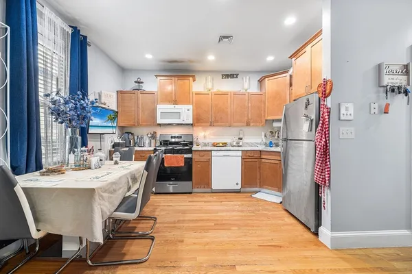 a kitchen with a table chairs refrigerator and cabinets
