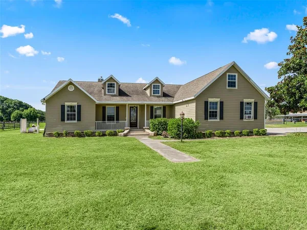 a front view of a house with a garden and yard