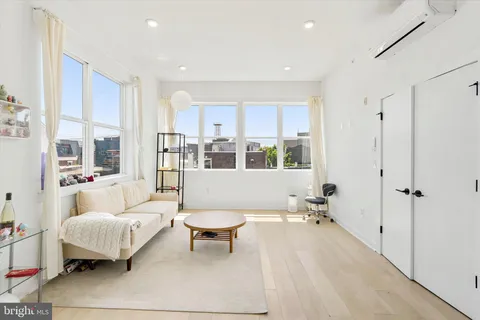 a living room with furniture a table and a large window