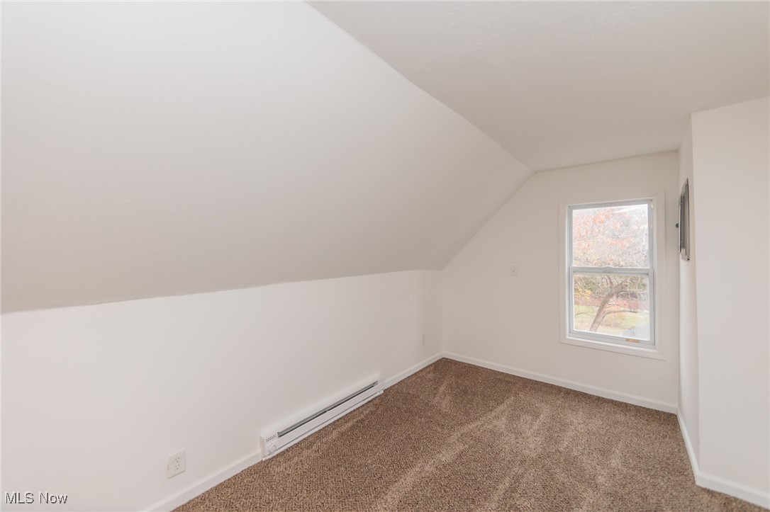 3181 Warren Road Cleveland, OH 44111 - Photo 21 of 28 Bonus room featuring lofted ceiling, carpet, and a baseboard heating unit