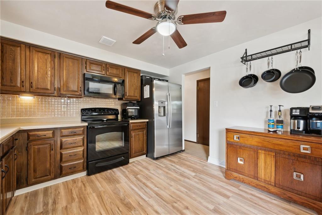 101 Edith Drive Hunker, PA 15639 - Photo 10 of 35 a kitchen with stainless steel appliances granite countertop a sink a stove top oven a refrigerator with cabinets and wooden floor