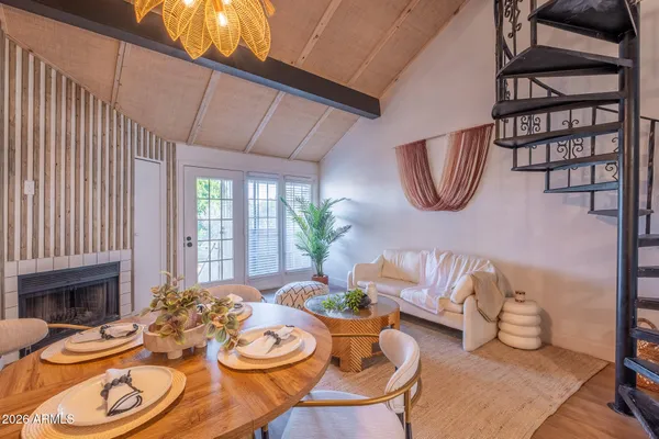 a dining room with furniture a fireplace and wooden floor