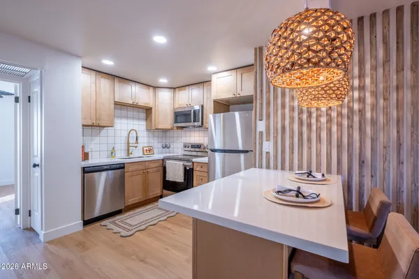 a kitchen with refrigerator cabinets and wooden floor