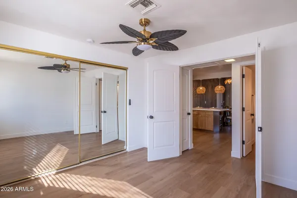 a view of a room with a ceiling fan and wooden floor