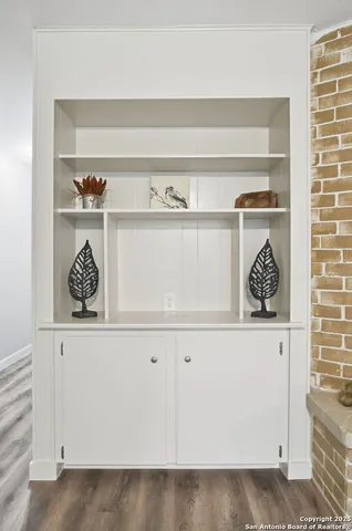 a white kitchen with white cabinets and a wooden floor