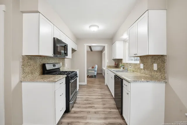 a large kitchen with stainless steel appliances granite countertop a stove top oven