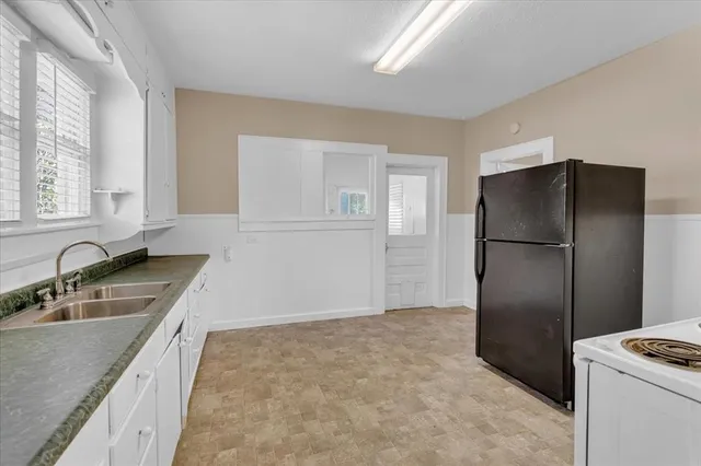 a kitchen with a refrigerator sink and cabinets