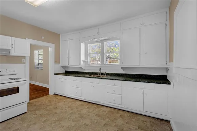 a kitchen with granite countertop white cabinets and sink