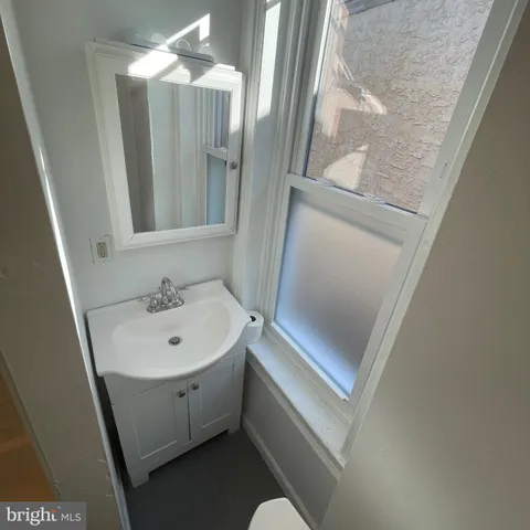 an empty room with wooden floor chandelier fan and windows