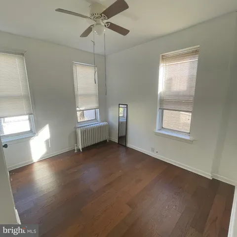 an empty room with windows and fan