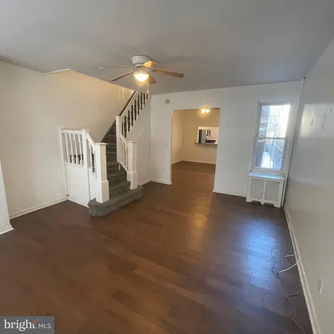 a view of a livingroom with wooden floor and stairs