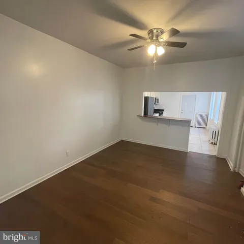 a view of a livingroom with a ceiling fan and wooden floor