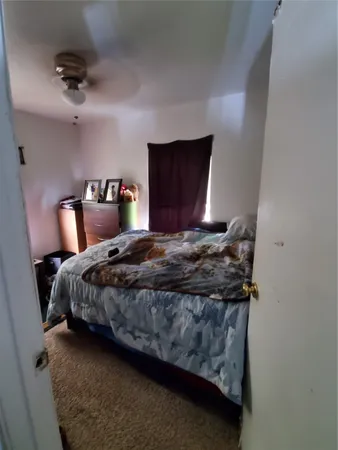 a bedroom with bed and a mirror