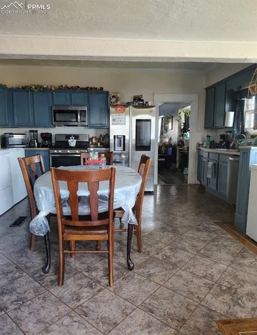 a dining room with a table chairs and a kitchen view