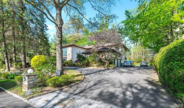 a front view of a house with a yard and potted plants