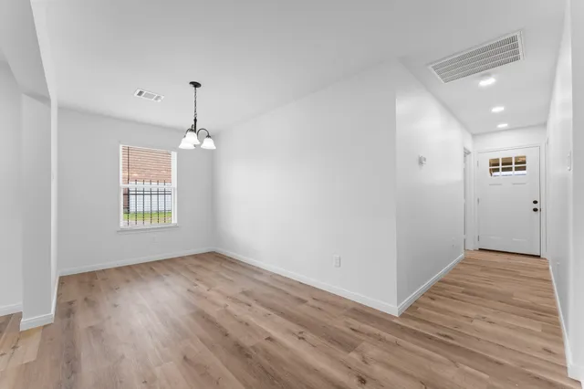 a kitchen with a refrigerator and white cabinets