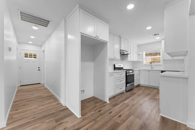 a kitchen with granite countertop white cabinets and white appliances