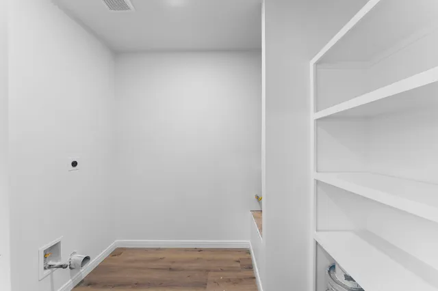 a view of room with wooden floor and white walls