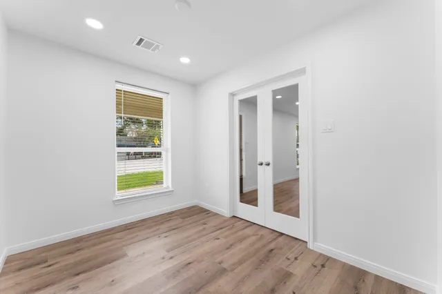 an empty room with wooden floor and a window
