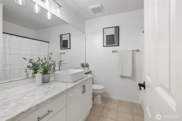 a bathroom with a granite countertop sink mirror and toilet