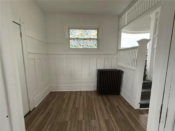 a view of a hallway with entryway and wooden floor