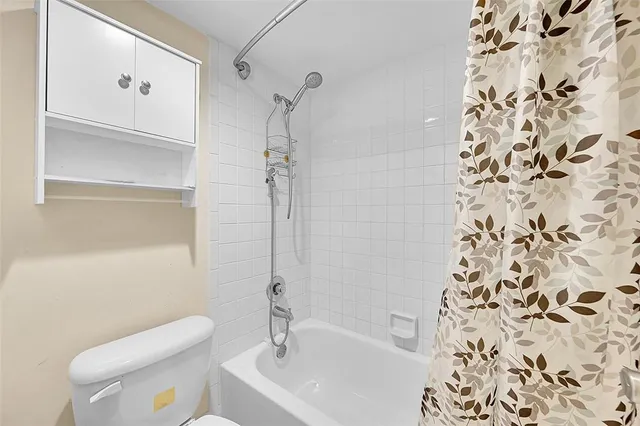 a bathroom with a toilet and a shower curtain