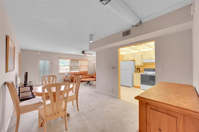 a large white kitchen with cabinets a sink a window and stainless steel appliances