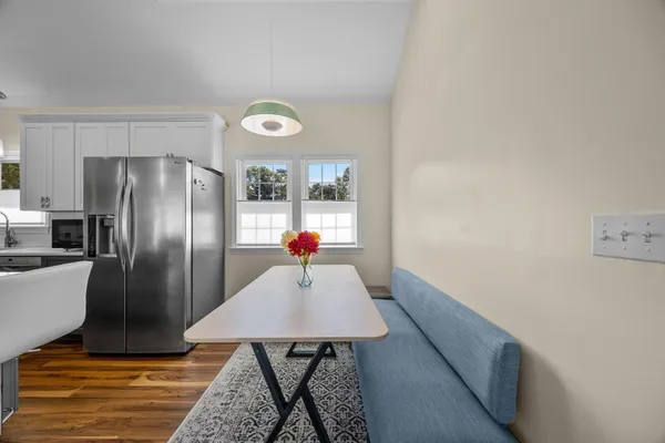 a kitchen with a refrigerator and wooden floor