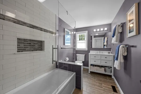 a bathroom with a bathtub sink and mirror