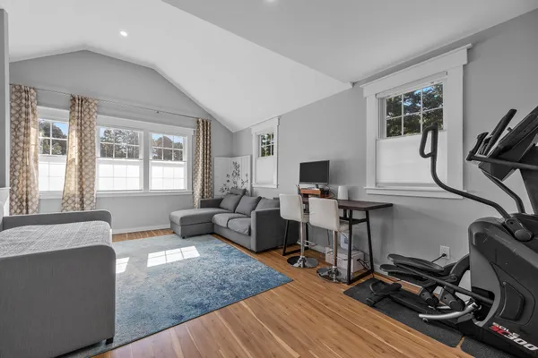 a living room with furniture a flat screen tv and a window